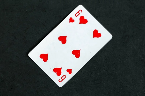 Six of Hearts playing card, black background, top view