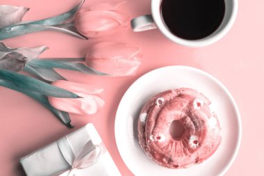 Lale buketi, tatlı çörek ve pembe arka planda kahve fincanı, tonlu fotoğraf.