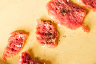 Masada çiğ et parçaları var. Malzemeyi pişirmeye hazır.