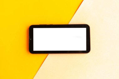 Renkli geometrik arkaplan üzerinde beyaz model ekranlı cep telefonu. 