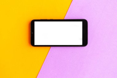 Renkli geometrik arkaplan üzerinde beyaz model ekranlı cep telefonu. 