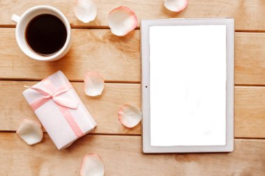 Kahve fincanı, hediye kutusu ve tahta arka planda beyaz tablet. Sevgililer Günü geçmişi. Metin için alanı kopyala