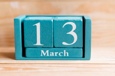 13 Mart. Ahşap zemin üzerinde ay ve tarih olan mavi küp takvimi.