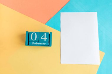 4 Şubat. Ay ve tarih ile mavi küp takvimi ve renk geometrik arkaplan üzerinde beyaz model boş. 