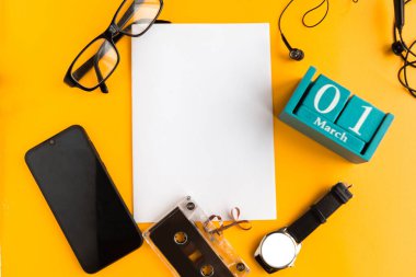 1 Mart. Ay ve tarih yazılı mavi küp takvimi ve turuncu arka planda beyaz model boş. 