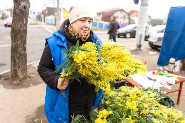  Kadının elinde mimoza dalları var. Belarus 'ta 8 Mart