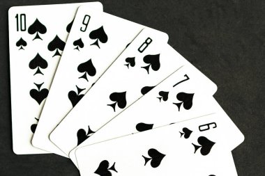Poker straight flush playing card, top view, black background