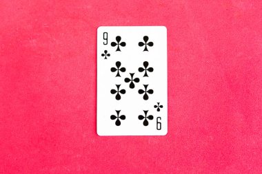 Nine of Clubs playing card on red background, top view, copy space