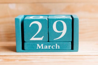 29 Mart. Ahşap zemin üzerinde ay ve tarih olan mavi küp takvimi.