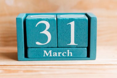 31 Mart. Ahşap zemin üzerinde ay ve tarih olan mavi küp takvimi.