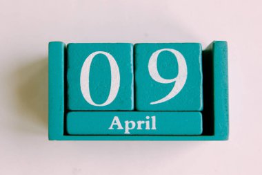 9 Nisan. Beyaz arkaplanda ay tarihi izole edilmiş mavi küp takvimi.