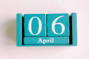 6 Nisan. Beyaz arkaplanda ay tarihi izole edilmiş mavi küp takvimi.