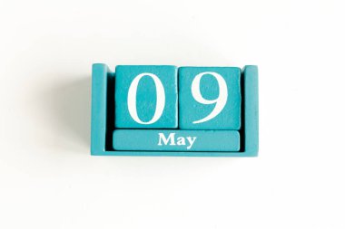 9 Mayıs. Beyaz arkaplanda ay tarihi izole edilmiş mavi küp takvimi.