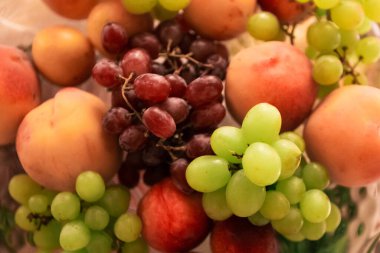 Raw different fruit on the plate, close up, top view