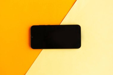 Renk geometrik arkaplanı üzerinde boş ekranı olan siyah akıllı telefon