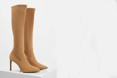 Stüdyoda izole edilmiş topuklu yüksek bej süet botların fotoğrafı. Metin için alanı kopyala