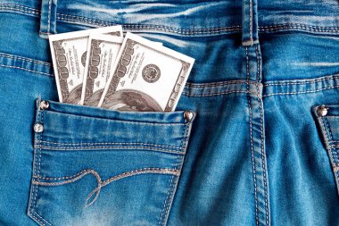 Kotun arka cebinde 100 dolarlık banknotlar var. Kotun cebindeki dolar banknotları yakın plan.