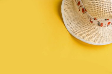 Parlak sarı arka planda hasır şapka. Yaz tatili kavramı. En düşük konsept, en üst görünüm