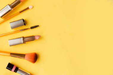 Açık sarı arka planda pembe ruj seti en az görünümde yatıyordu. Güzellik ve kozmetik geçmişi. Dekoratif kozmetik, makyaj, kadın ruju, güzellik markası, ürün tasarımı