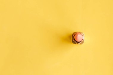 Parlak sarı arka planda pembe ruj. Güzellik ve kozmetik geçmişi. Dekoratif kozmetik, makyaj, kadın ruju, güzellik markası, ürün tasarımı. Düz konum, üst görünüm, kopyalama alanı, en küçük konsept