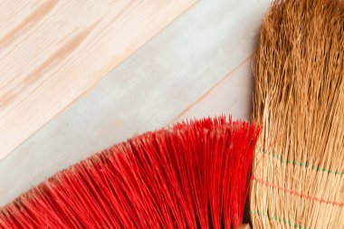 Tahta arka planda süpürge ve paspas. Bahar temizliği kavramı. 