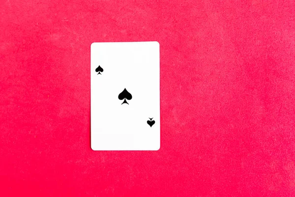 Ace of spades playing card on red background, top view, copy space