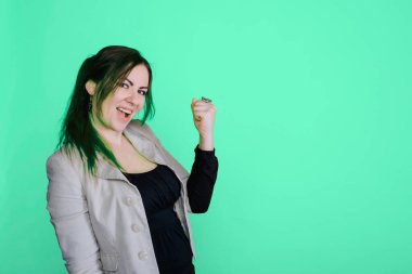 Stüdyodaki esmer kadının portresi. Pastel yeşili izole edilmiş arka plan. Kız evet işareti gösteriyor. Boşluğu kopyala