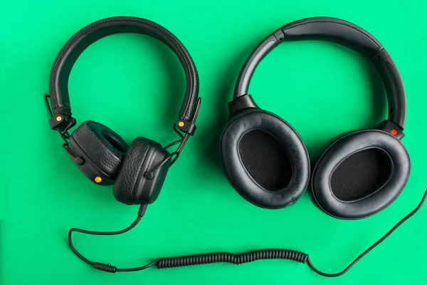 Dos Auriculares Negros Vintage Aislados Sobre Fondo Verde Brillante — Foto de Stock