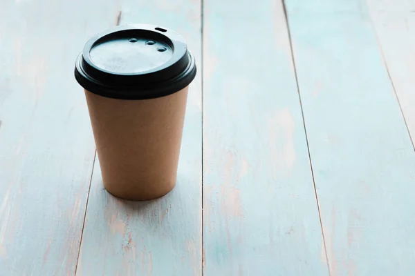 Takeaway coffee cup on wooden background, top view