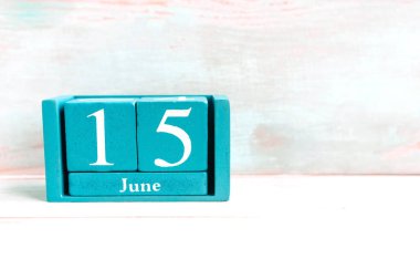 15 Haziran. Ahşap arkaplanda ay tarihi izole edilmiş mavi küp takvimi.