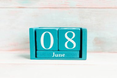8 Haziran. Ahşap arkaplanda ay tarihi izole edilmiş mavi küp takvimi.