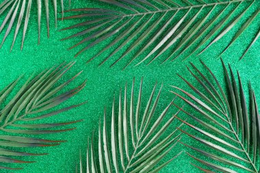 Yeşil simli arka planda yeşil palmiye yaprakları deseni