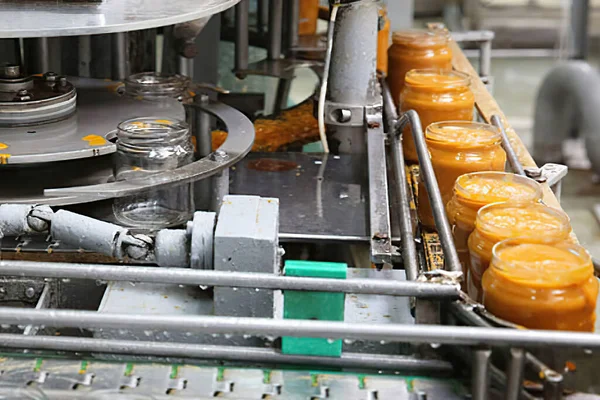 Konserve gıda üretim hattı. Taşıma bandında kabak havyarı olan bir sürü kavanoz.
