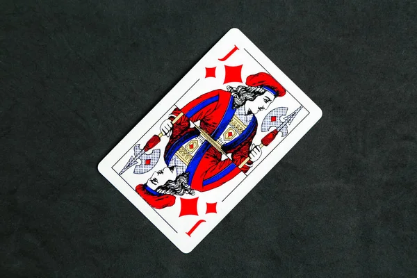 Joker of diamonds playing card, wooden background, copy space