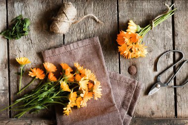 Eski ahşap masada makas, çiçek ve iplik, üst manzara.. 