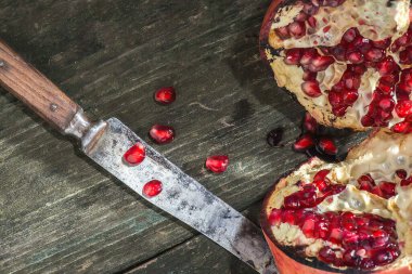 Dilimlenmiş nar ve tahta üzerinde bıçak.