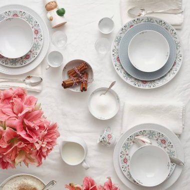 Beyaz sofra takımı ve pembe orkide çiçekleriyle servis edilen açık büfenin düz yatağı.