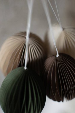 Paskalya Bayramı 2026 bahar dekoratif süsü olarak sunulan kağıt asılı Paskalya yumurtası, beyaz arka planda hafif işçilik dokusu ile izole edilmiştir.