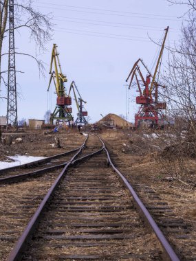 Deniz ticaret limanındaki vinçlerin altındaki demiryolu rayları.