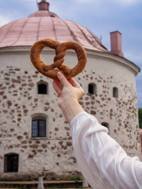 Vyborg simit eski yuvarlak kulenin arka planına karşı elde (Vyborg Sembolü)