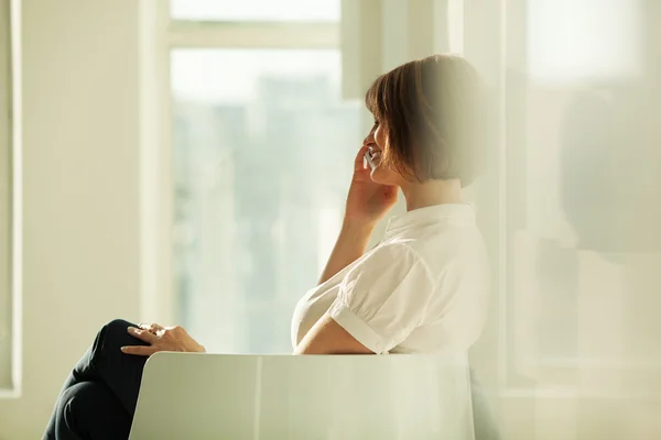 Side view of smiling businesswoman talking on phone — Stock Photo, Image