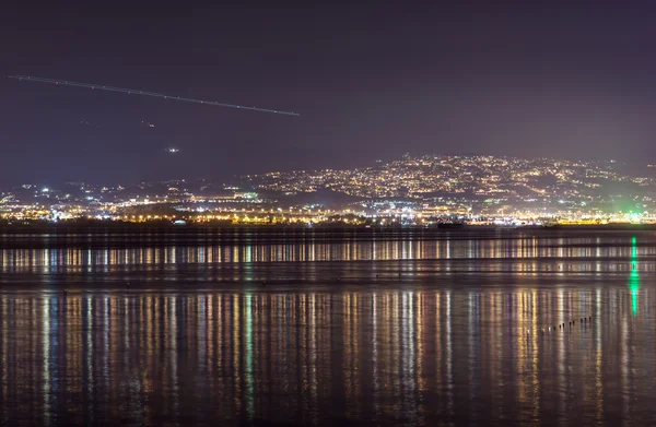 Lichtstreifen am Himmel über der Stadt in der Nacht — Stockfoto