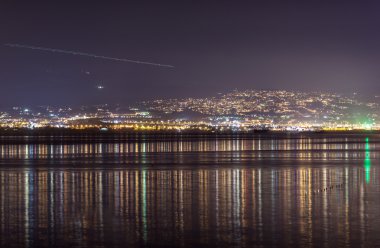 Gece şehir üzerinde gökyüzünde ışık çizgi