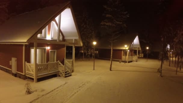 Voando sobre pequena casa de madeira na noite de inverno — Vídeo de Stock