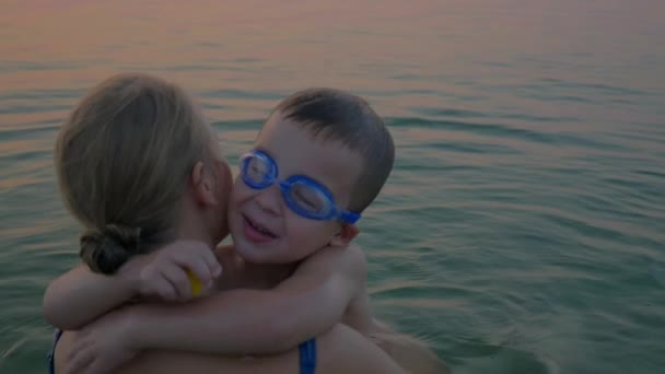 Hugs and kisses of mother with son in the sea — Stock Video