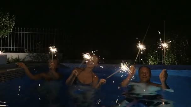 Familie mit Bengalfeuern tanzt im Pool — Stockvideo