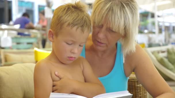 Grand-mère lisant un livre au petit-fils — Video