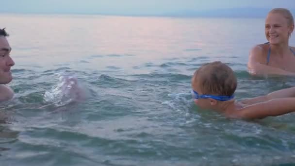 Счастливая семья веселится в воде на отдыхе — стоковое видео