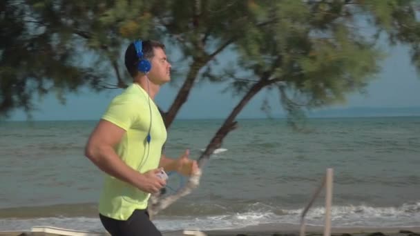 Correr con música y smartphone en la playa — Vídeo de stock