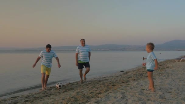 Семейная футбольная команда играет на берегу моря — стоковое видео